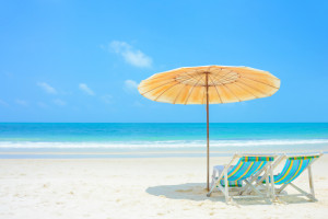 Blue sea and white sand beach with beach chairs